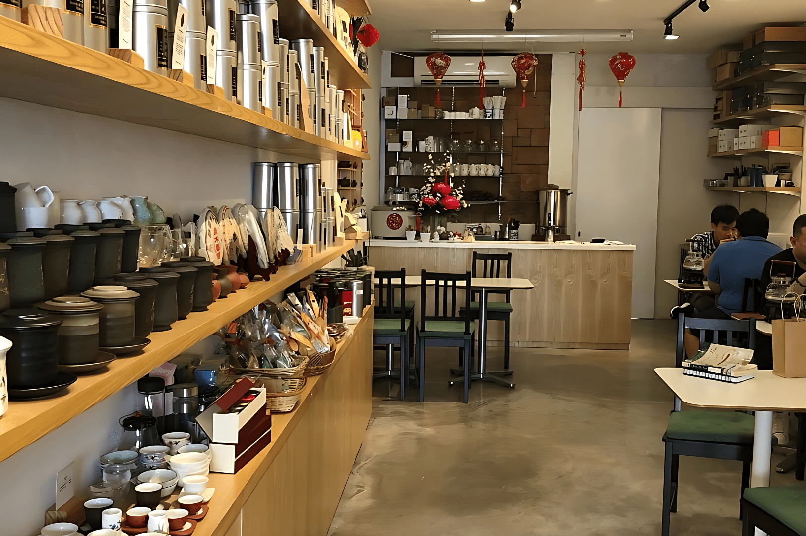 Interior of Yixing Xuan Teahouse in Singapore, featuring shelves of premium Chinese teas and teaware, with seating for guests to enjoy authentic Long jing (Dragon Well) tea—highlighting a top highly recommended destination to purchase Longjing tea in Singapore.