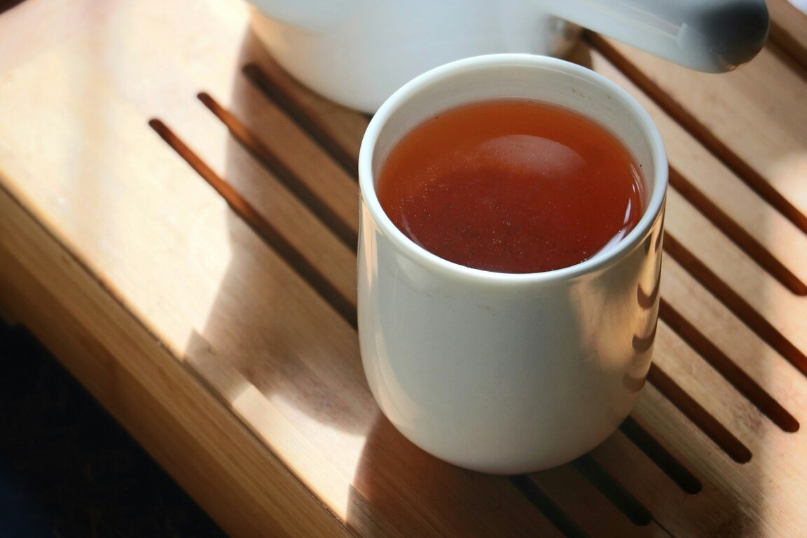 Oolong Tea Oxidation : A cup of freshly brewed oolong tea with golden amber hues and rising steam.