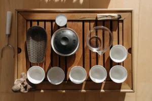 Traditional Gongfu tea set with gaiwan and cups on a slatted wooden tray.